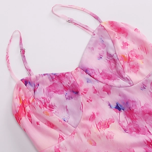 Detailed view of adjustable spaghetti straps and mesh marble print on a pink dress