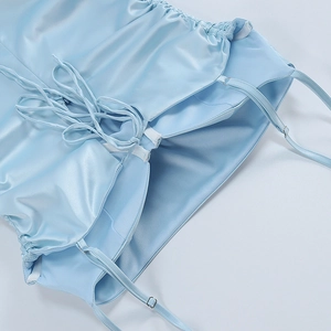 Detail of light blue satin dress featuring thin straps with metal adjusters and drawstring