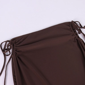 Detail of dark brown knit skirt with adjustable side drawstrings and ruched texture