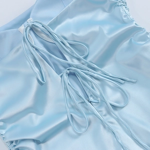 Detail view of light blue satin dress featuring side drawstring and hidden zipper