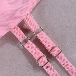Detail of pink mesh dress featuring adjustable shoulder straps with silver metal rings