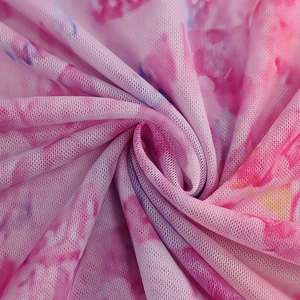 Detail of pink floral mesh fabric with a breathable, sheer texture and dye patterns