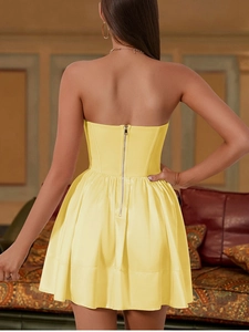 Detailed back view of a yellow mesh mini dress with corset waist and metal zipper closure