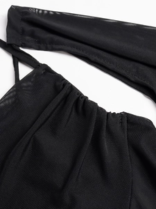 Detailed close-up of black sheer mesh fabric with spaghetti straps and ruched stitching