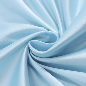 Detail of light blue satin dress fabric showing smooth texture and glossy drape finish