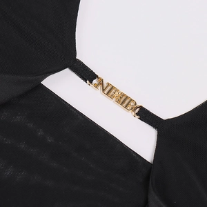 Detail of black mesh fabric dress featuring a golden NIBO metal spider buckle