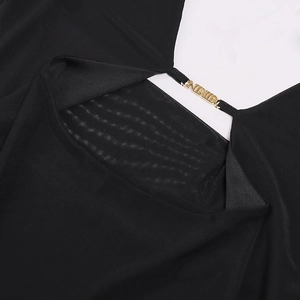 Detail of black mesh fabric with a golden metal logo buckle on the neckline