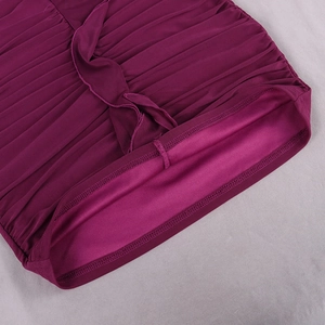 Détail macro du tissu en maille plissée magenta avec ourlet à volants et surjet intérieur