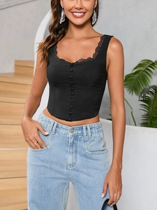 Dettaglio del top a corsetto nero con bordo in pizzo e bottoni decorativi centrali