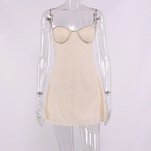 Close-up of rhinestone-embellished bust line on a white sequin mini slip dress