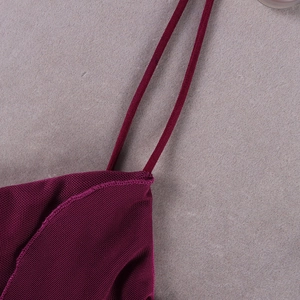 Détail du tissu en maille bordeaux et de la fine bretelle sur une robe froncée