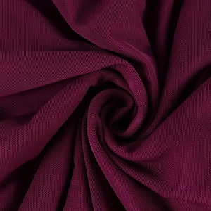 Texture macro détaillée du tissu en maille bordeaux respirant avec plis souples