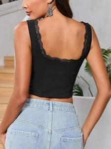 Dettaglio del corsetto nero con scollatura a U sulla schiena e bordo in pizzo ciglia