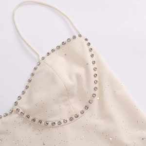 Close-up of beige mesh dress showing silver sequins and rhinestone-embellished neckline