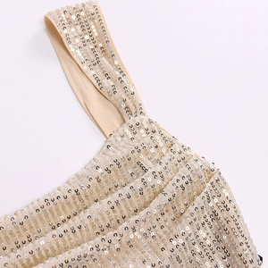 Close-up of champagne gold sequins on mesh fabric with elegant thin shoulder straps