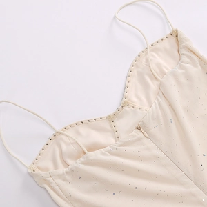 Detail of sequined mesh dress featuring rhinestone neckline and delicate spaghetti straps