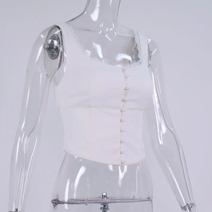 Dettaglio del corsetto bianco con pizzo delicato e bottoni su manichino trasparente