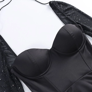 Détail de la robe en maille noire avec décolleté en cœur, paillettes et bonnets intégrés