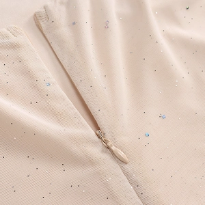 Close-up of beige mesh fabric with shimmering sequins and concealed zipper detail