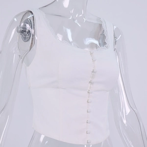 Dettaglio del corsetto bianco con fila di bottoni e bordo in pizzo sullo scollo