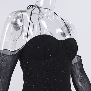 Détail d'une robe moulante à paillettes avec manches longues en mesh et style licou
