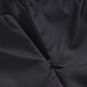 Gros plan macro de la fermeture éclair invisible sur cette robe de soirée noire à paillettes