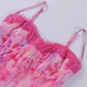 Détail de la bordure en dentelle rose et du tissu en maille tie-dye sur la robe