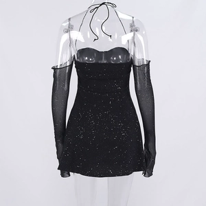 Détail d'une robe moulante à paillettes noires avec licou et manches longues en mesh