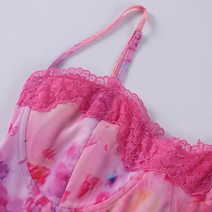 Détail de dentelle florale rose sur une robe en maille tie-dye avec bretelles fines