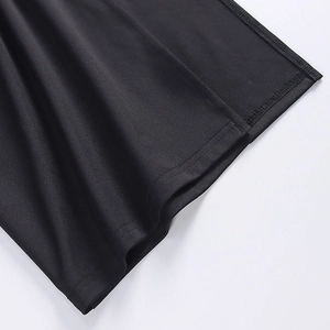 Gros plan de l'ourlet de la robe noire avec des détails de couture à double aiguille