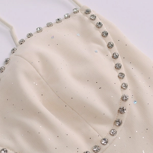 Macro detail of beige mesh top featuring shimmering fabric and rhinestone neckline trim