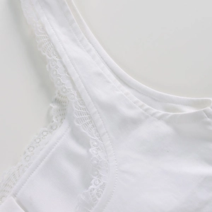 Dettaglio del corsetto bianco con bordo in pizzo delicato e cuciture a doppio ago premium