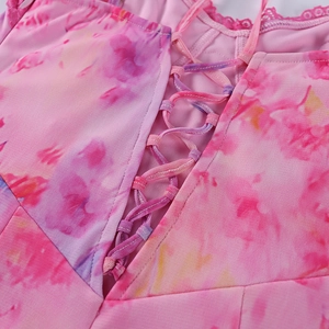 Détail du corsage à lacets avec bordure en dentelle rose et tissu mesh tie-dye