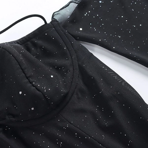 Détail d'une robe en résille noire avec paillettes argentées et décolleté style corset