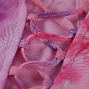Détail de robe en mesh tie-dye rose et violet avec laçage croisé et texture fine