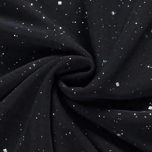 Détail du tissu en maille noire orné de paillettes argentées brillantes pour robe