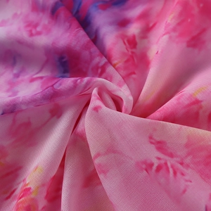 Détail macro du tissu en maille respirant avec motif tie-dye rose et violet doux