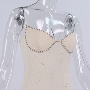 Détail de la robe beige à paillettes avec encolure en strass et texture de tissu brillant