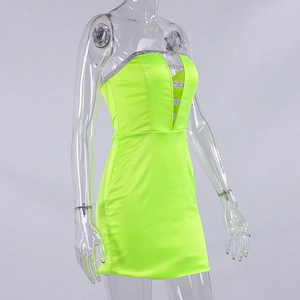 Detail of neon green strapless mini dress with silver glitter trim and cutout design