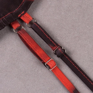Detail of adjustable straps with silver metal rings and red contrast stitching on a dress