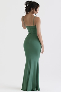 Detail view of emerald green bodycon dress showing back slit and elegant mermaid hemline
