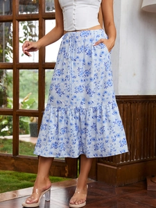 Detail of blue floral midi skirt with drawstring waist and ruffled hem on a model