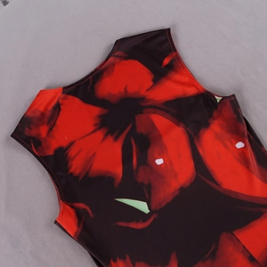 Detail view of the sleeveless neckline featuring red floral print on black fabric