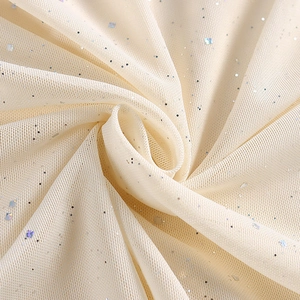 Gros plan sur un tissu en tulle crème orné de paillettes argentées scintillantes