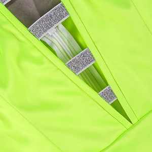 Detail of neon green dress featuring V-neckline with shimmering silver straps and layering