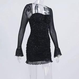 Dettaglio abito aderente con paillettes drappeggiate e maniche in mesh trasparente