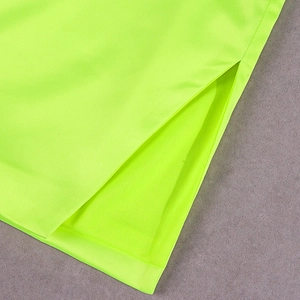 Detail view of the side slit and neon green mesh fabric texture on the midi dress