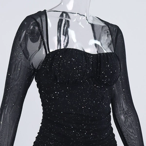 Dettaglio mini abito nero con paillettes, maniche in tulle trasparente e scollo a cuore