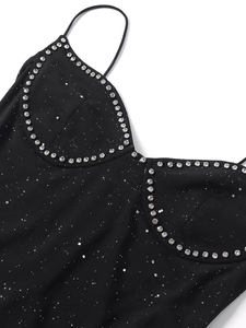 Détail du décolleté en cœur sur robe en résille noire avec paillettes et strass argentés