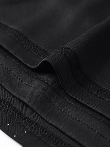 Détail macro des coutures à double aiguille et du tissu en maille sur la robe noire